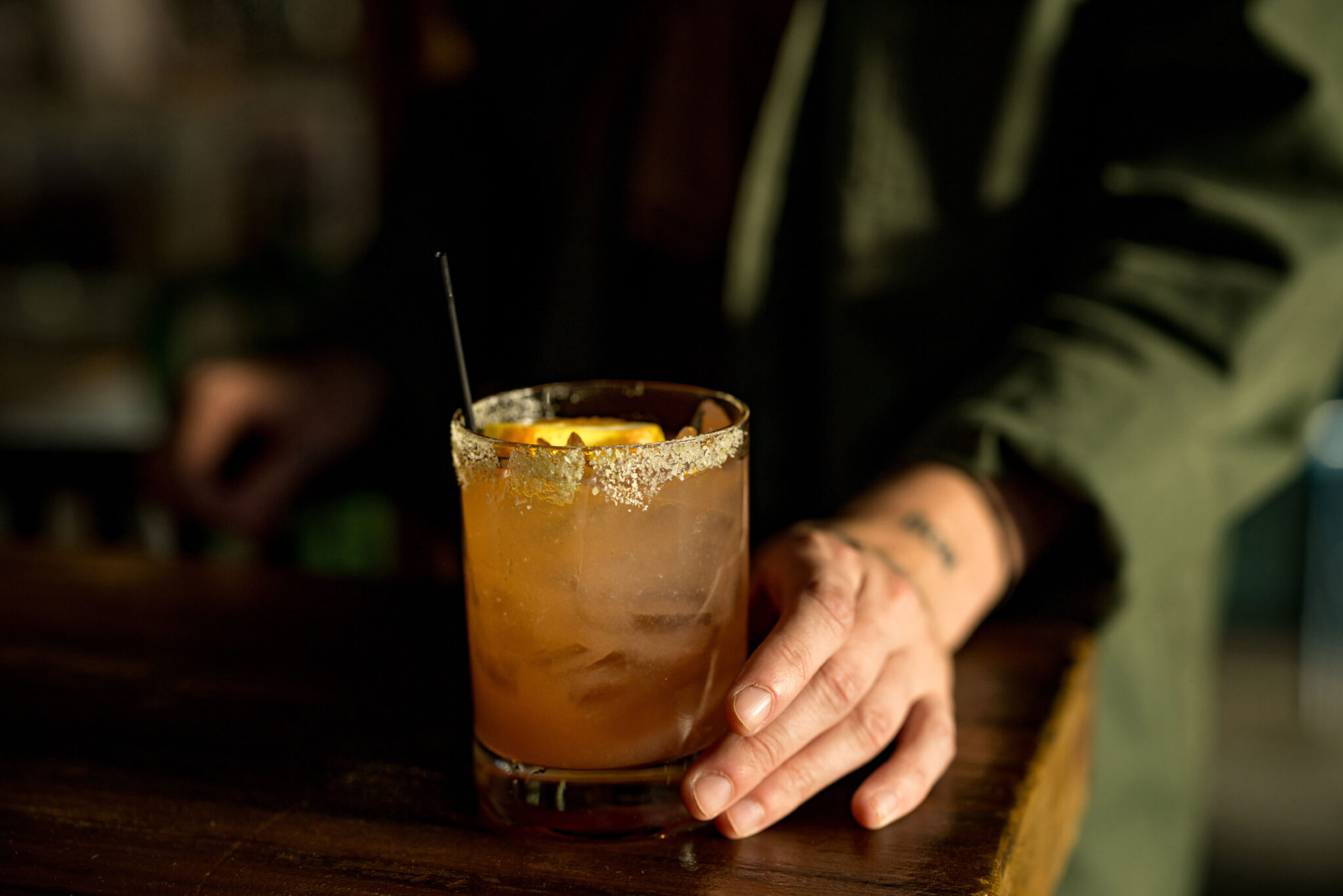 Person's hand holding a craft beverage