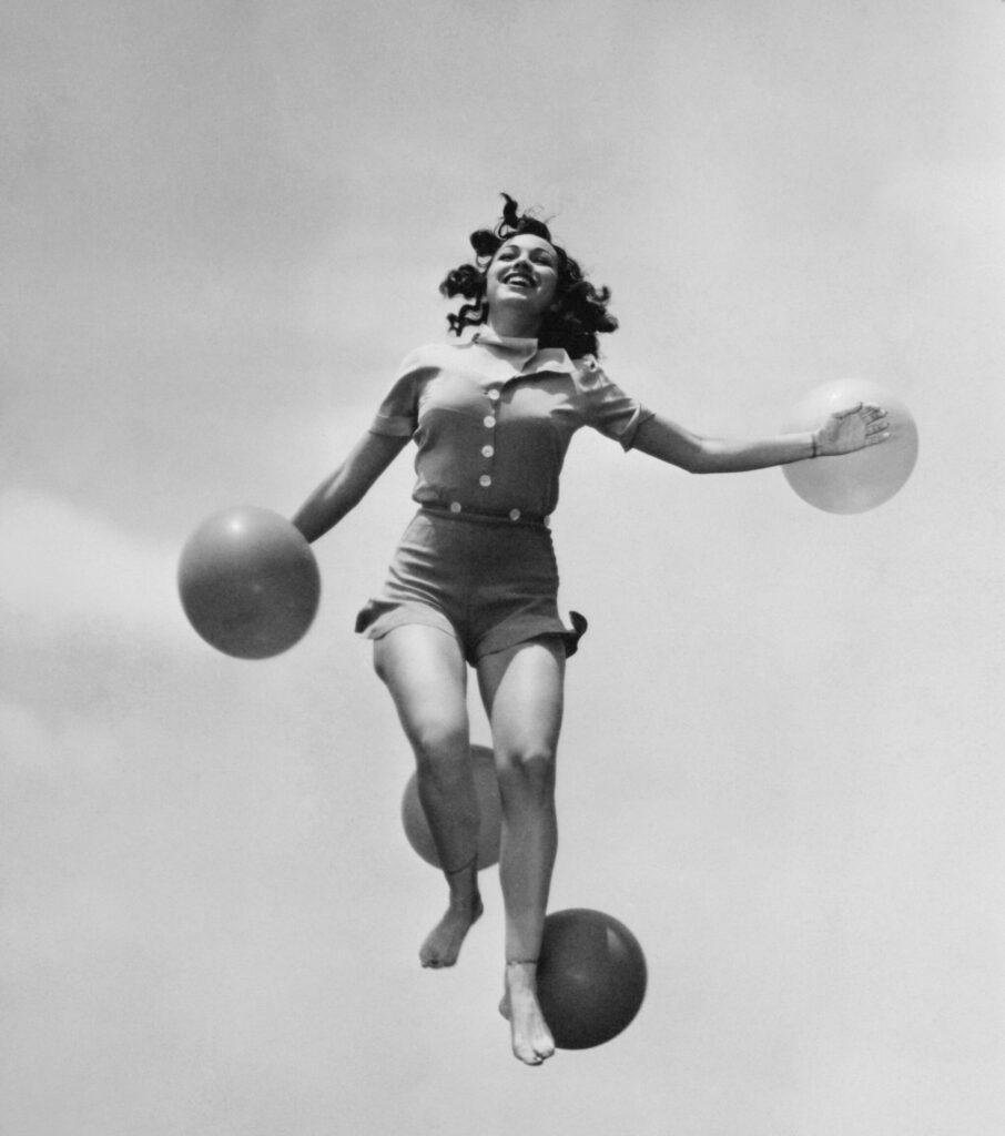 Woman jumping outside with balloons